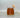 Glas mit bernsteinfarbenem, flüssigem Speisehonig und Holz-Honiglöffel vor grauem Hintergrund